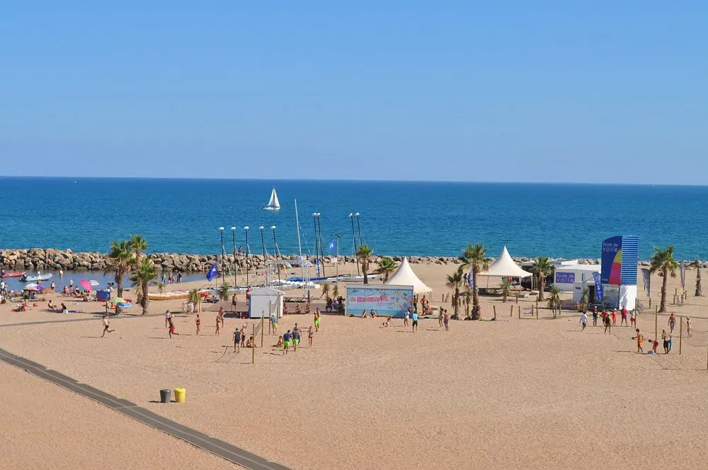 Plage de Valras animée avec mer bleue et ciel bleu dégagé