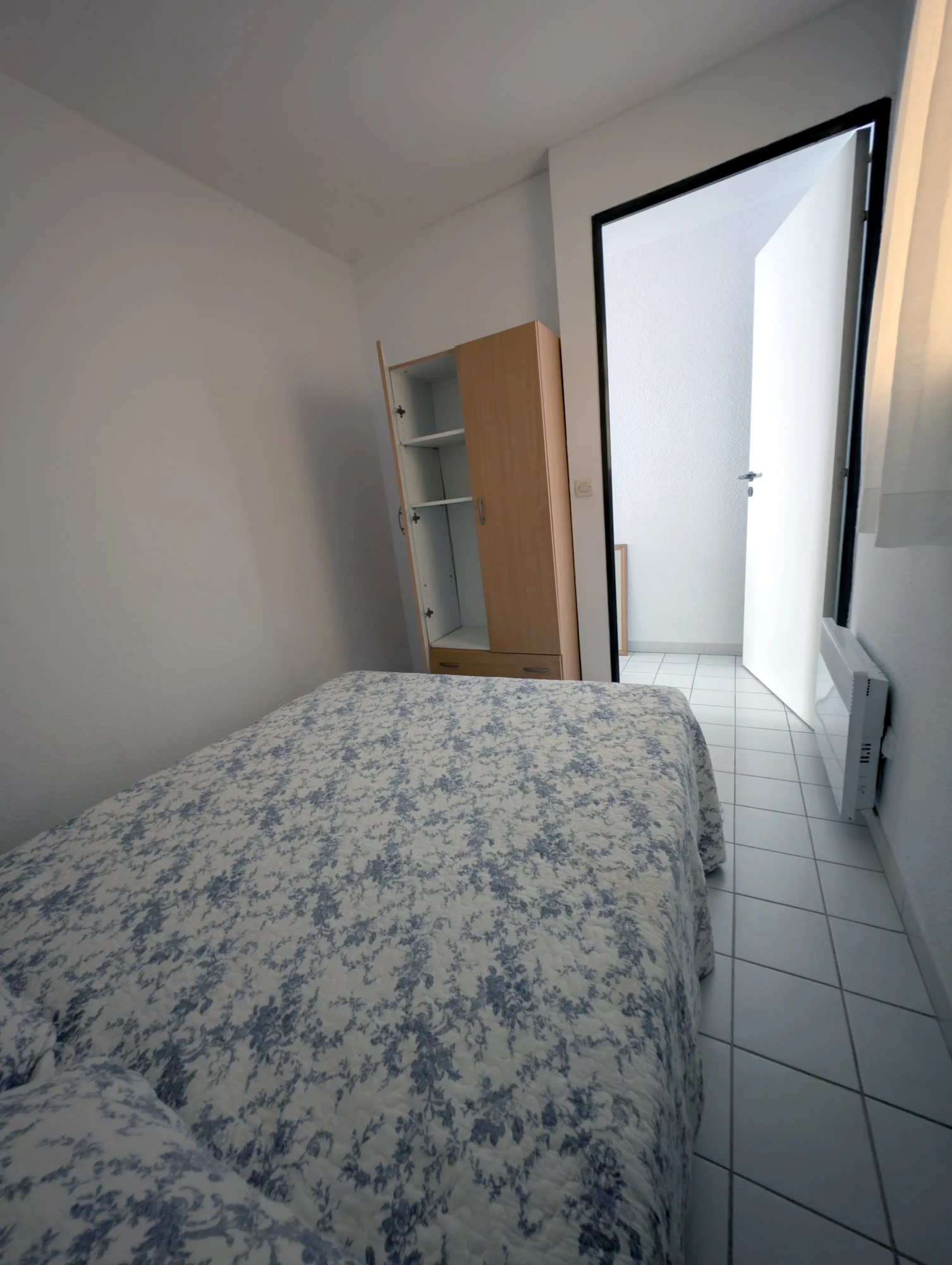 Chambre avec armoire de rangement et chauffage électrique